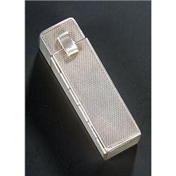 A rectangular engine turned lipstick holder, the cover with a hinged and sprung cover with intern...