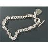 Image 1 : A Tiffany &  Co silver necklace, with a heart shaped pendant and hoop and bar clasp, London 2002,...