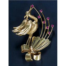 An Italian gold and ruby brooch, in the form of a stylised stork flying over a ribbon tied flower...