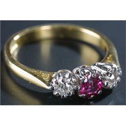 A modern 18ct gold, ruby and diamond three stone ring, centred with a cushion-shaped mixed-cut ru...