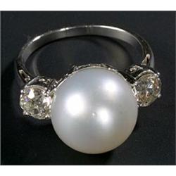 A South Sea cultured pearl and diamond three stone ring, the round bead approx. 12mm diameter bet...