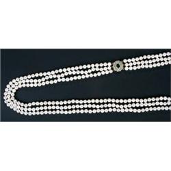 A cultured pearl graduated three row necklace with an emerald and diamond cluster clasp, the unif...