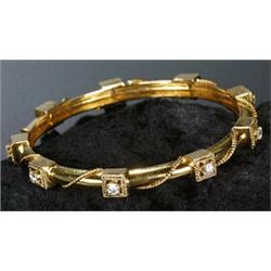 A diamond slave bangle in the form of a rope-work bound yellow hoop with nine round brilliant dia...