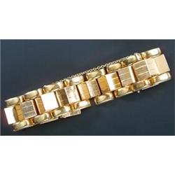 A modern broad block bracelet, the heavy articulated three row design with a central band of rais...