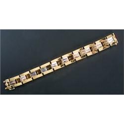 A modern 18ct bi-colour gold broad block bracelet, of articulated three row design with a central...