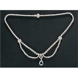A sapphire and diamond necklace, the front designed as swags with flower-head terminals and a cen...