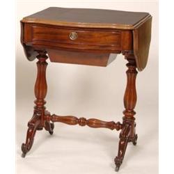 A Victorian Mahogany Work Table, the twin flap serpentine top above a frieze drawer and a work bo...