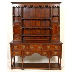 A George III Style Oak Dresser, cross banded, the dentil cornice above a shaped and pierced friez...