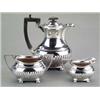 Image 1 : SILVER - An Edwardian boat shaped hot water jug, two-handled sucrier and cream jug, on ball feet...