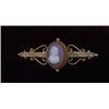 Image 1 : JEWELLERY AND WATCHES - A 9ct gold stone cameo bar brooch, the decorative bar of scroll and foli...