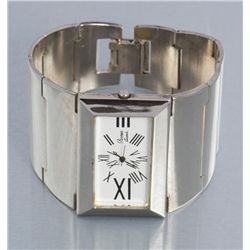 One unique ladies 2” wide wrist watch with a  rectangle face and roman numerals could be silver.   E