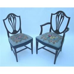 A set of 8 Hepplewhite style mahogany dining chairs, each having carved and pierced shield back a...