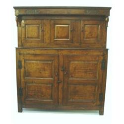 A George II oak press cupboard, the cornice initialled `R.A.P' and dated 1743 over recessed cupbo...