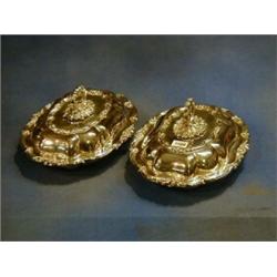 A pair of silver plated shaped entree dishes and covers £70-90...