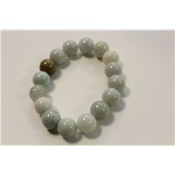 ONE ELASTICISED BRACELET OF 16 PALE GREEN JADE BEADS.  APPROX. 19CM LONG.  REPLACEMENT VALUE: