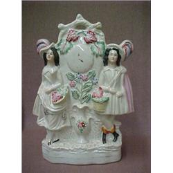 Staffordshire double figurine, woman and man on either side of clock, over vase with flowers, 12...