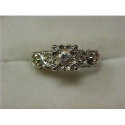 14K white gold and diamond ring, approximately 20 point center stone with two 1/2 point stones on...