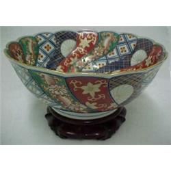 Imari bowl on wooden stand, scalloped rim with undulating design, interior center Chinese script,...