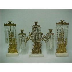 A set of three brass figural girandole, center triple candleholder flanked by single candleholder...