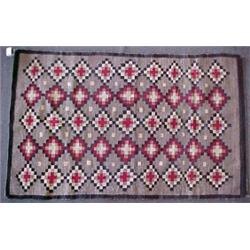 Navajo rug with dark brown and black border, and red, black, white and grey diamond pattern in sq...