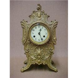 French style brass mantle clock by Waterbury, raised swirl, leaf and floral decoration, with key...