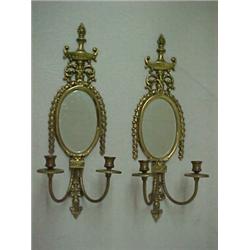 A pair of brass double sconses, flame and urn finial over oval mirror with hanging swag decoratio...