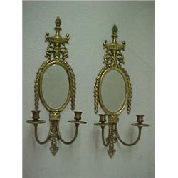 A pair of brass double sconses, flame and urn finial over oval mirror with hanging swag decoratio...