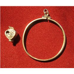 818. (2) Silver Charms – a silver dollar bezel and a hinged / hollow heart shaped charm