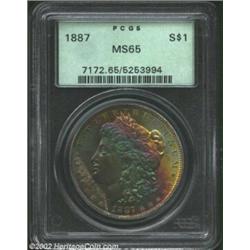 1887 S$1 MS65 PCGS. The obverse has vivid bands of gold, violet, and apple-green patina. The base of