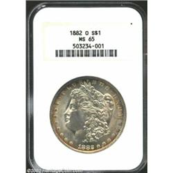 1882-O S$1 MS65 NGC. The margins have bright lemon-gold patina, along with wisps of electric-blue co