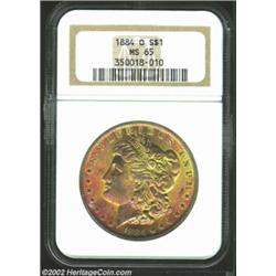 1884-O S$1 MS65 NGC. The obverse has iridescent bright rose and orange patina, while the reverse is.