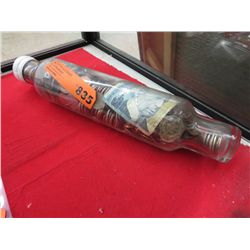 Sealed bottle full of assorted coins & bills