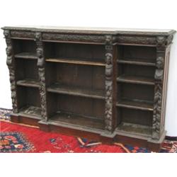Victorian carved oak breakfront open bookcase profusely decorated with masks,...