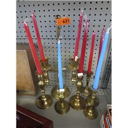 7 Brass candle holders with candles.