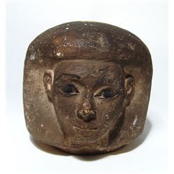 An Egyptian limestone lid for a canopic jar