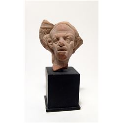 An Egyptian terracotta head of a Harpokrates