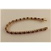 Image 2 : ONE 10KT YELLOW GOLD AND RHODIUM FINISH RUBY AND DIAMOND SET BRACELET. SET WITH A TOTAL OF 22 OVAL
