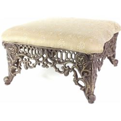 Footstool with padded top on cast iron base.