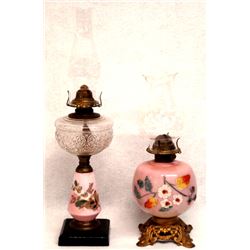 Two 20th C parlor oil lamps 1) metal base with pale rose colored glass and hand painted flowers unde