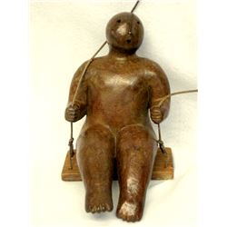 Bronze sculpture of modernistic child sitting on swing supported by nylon rope signed Joy Brown of K