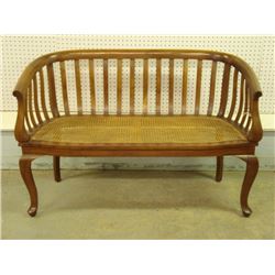 An Edwardian settee with caned seat and shaped vertical slat back and sides, 47" L x 31" H. Very goo