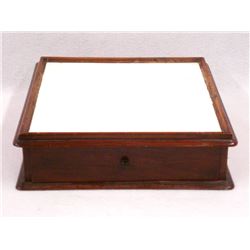 Table top wooden dental cabinet having an inset milk glass top over four small drawers on one side a