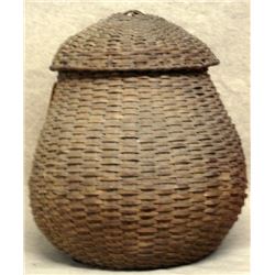 Large covered splint feather basket filled with wine corks. Basket has lost it's shape due to the we