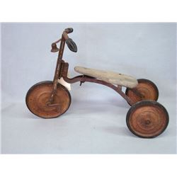 Early 20th C. tricycle with a wooden seat and hard rubber wheels, remnants of old red paint and whit