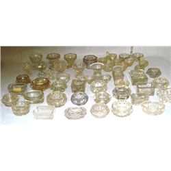 Large grouping of 40+ clear glass mostly master salt cellars including footed, double salts, some wi