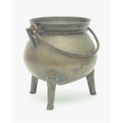 An Islamic bronze candlestick, 17th/18th century, with dished circular base and triple knopped cy...