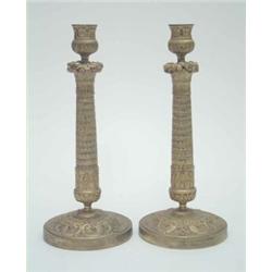 A pair of 19th century gilt brass candlesticks of Empire design, cast with bands of guilloche on...