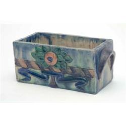 A studio pottery flower trough, decorated with a stylised tree against a ground of mottled blues...