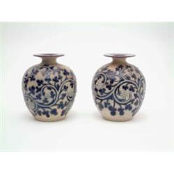 A pair of George Tinworth Doulton vases, with flared rims and narrow necks of globular form, each...