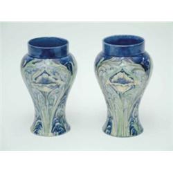 A pair of MacIntyre Moorcroft Florian ware baluster vases, decorated in yellows and greens agains...